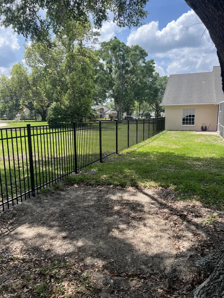 Black aluminum fence wrapping the side and rear of a Florida home